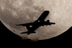 満月を横切る航空機